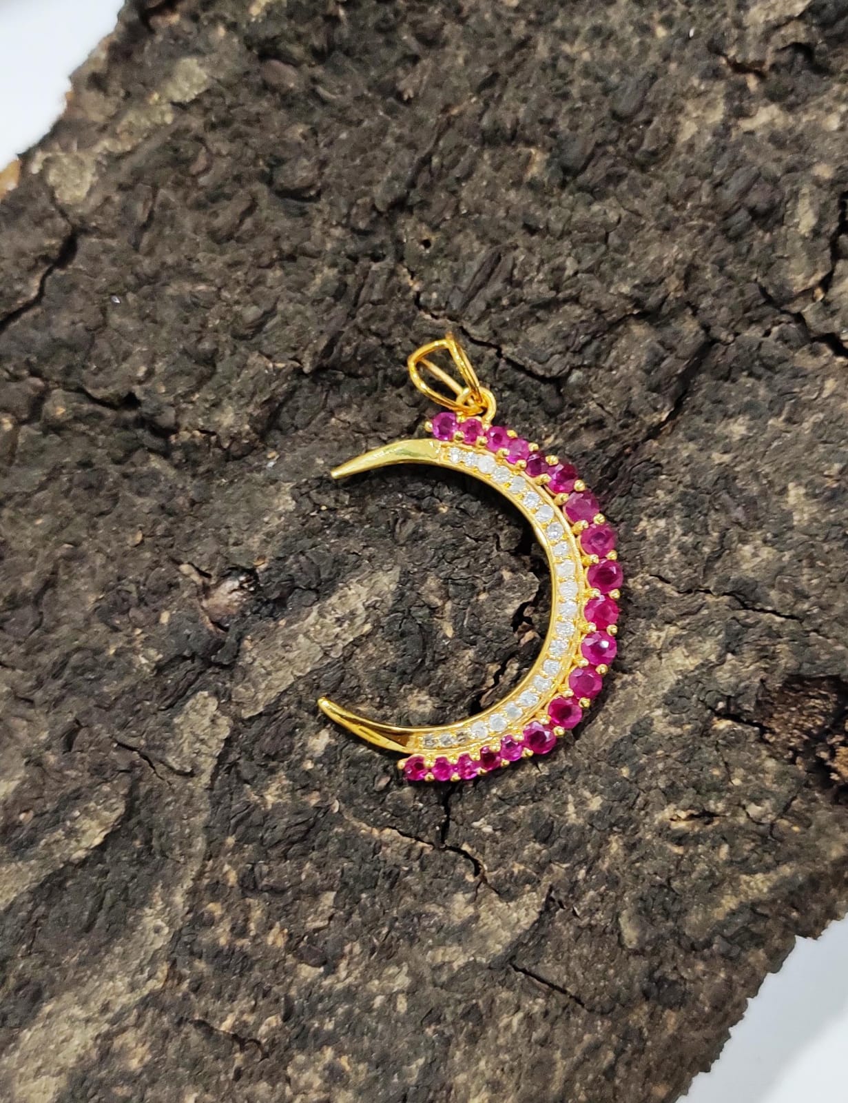 Crescent pendant in 18 karat gold with diamonds and rubies.