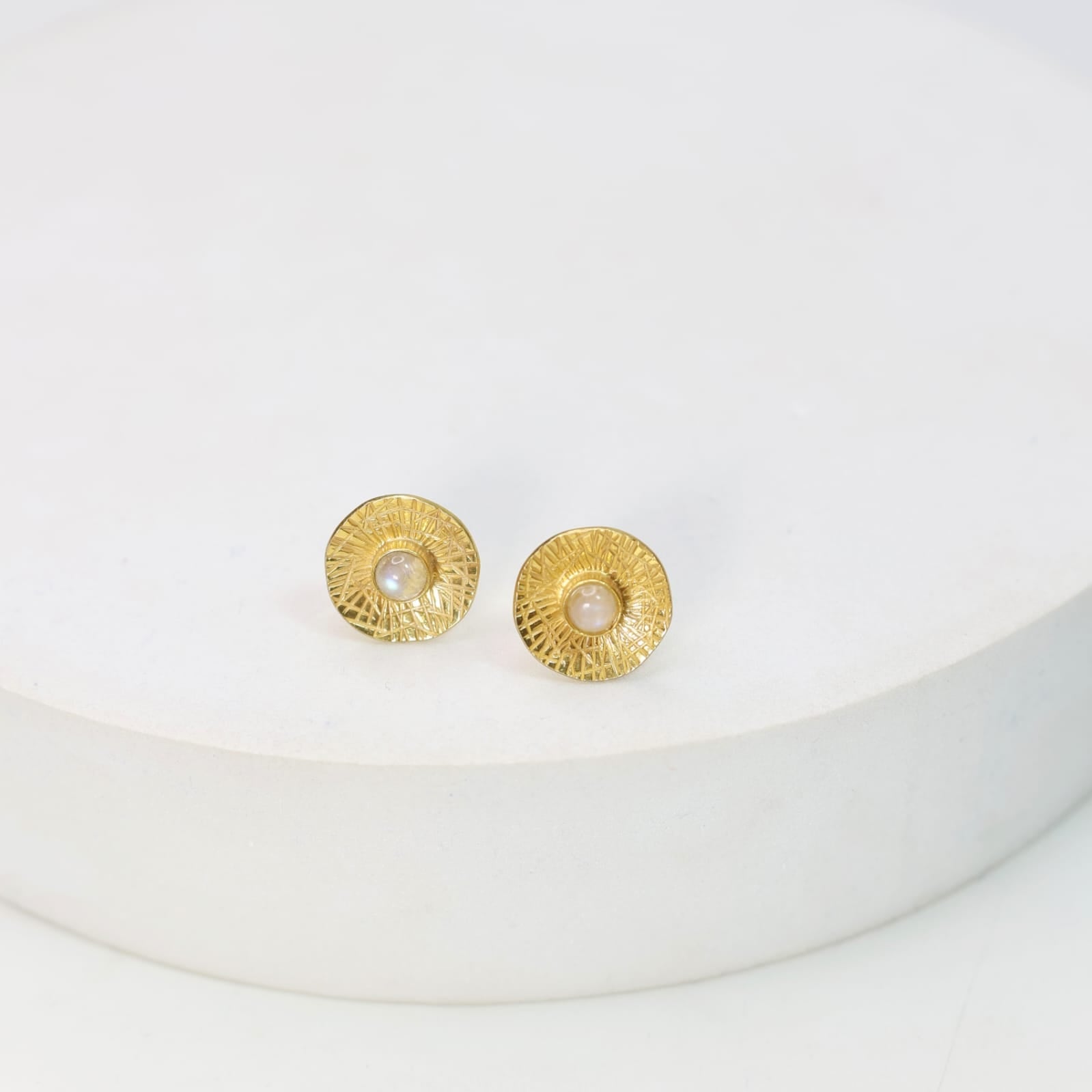 Sterling Silver stud earrings with 18 karat micron plating patterned tops with moonstones in Push-Post closure.