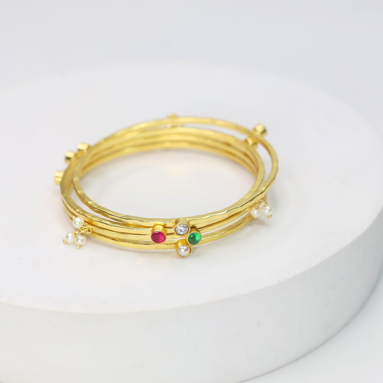Stacking Bracelet/Bangle in
92.5 sterling Silver, 18 karat Gold plating with Pearls, Polki, red Quartz and green Onyx.
(Set of 4).