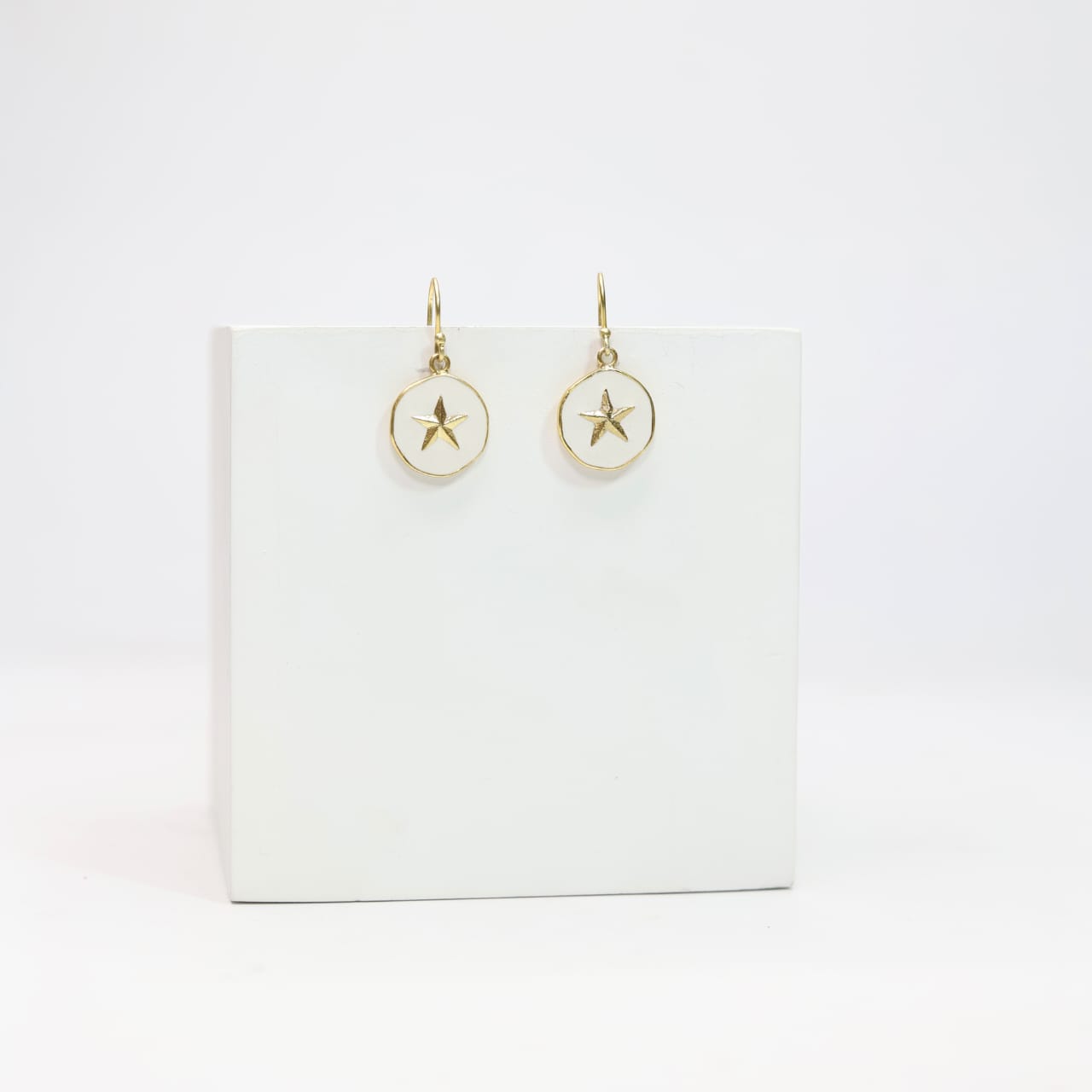 Sterling Silver star hook earrings with white enamel in 18 karat Gold plating.
