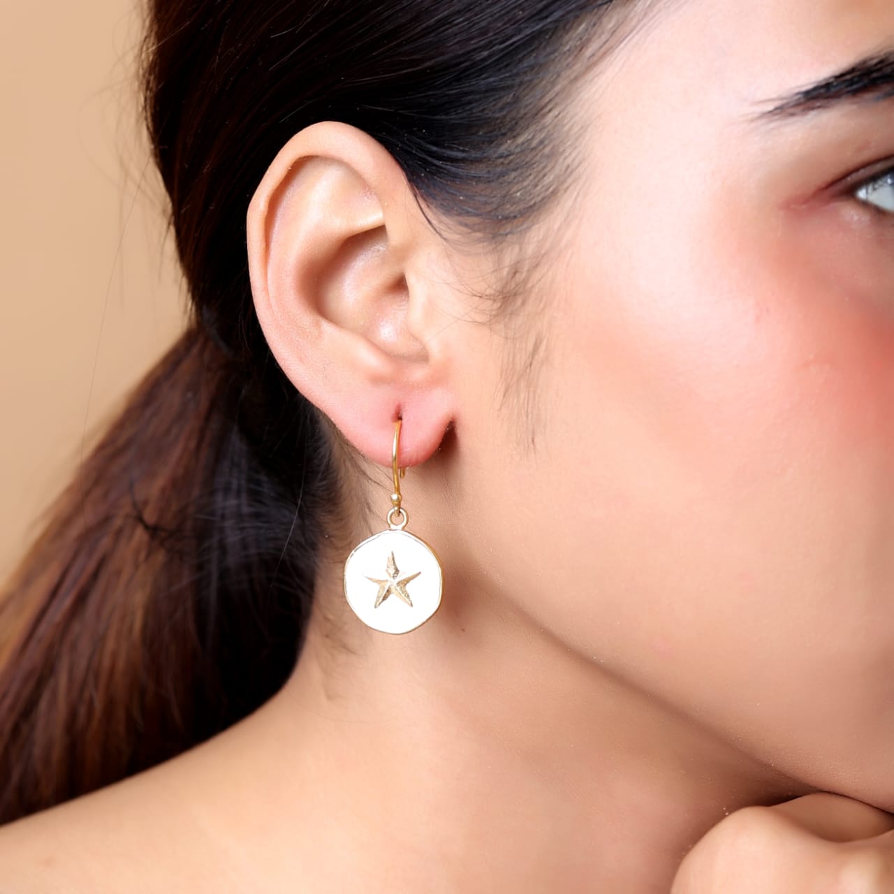 Sterling Silver star hook earrings with white enamel in 18 karat Gold plating.