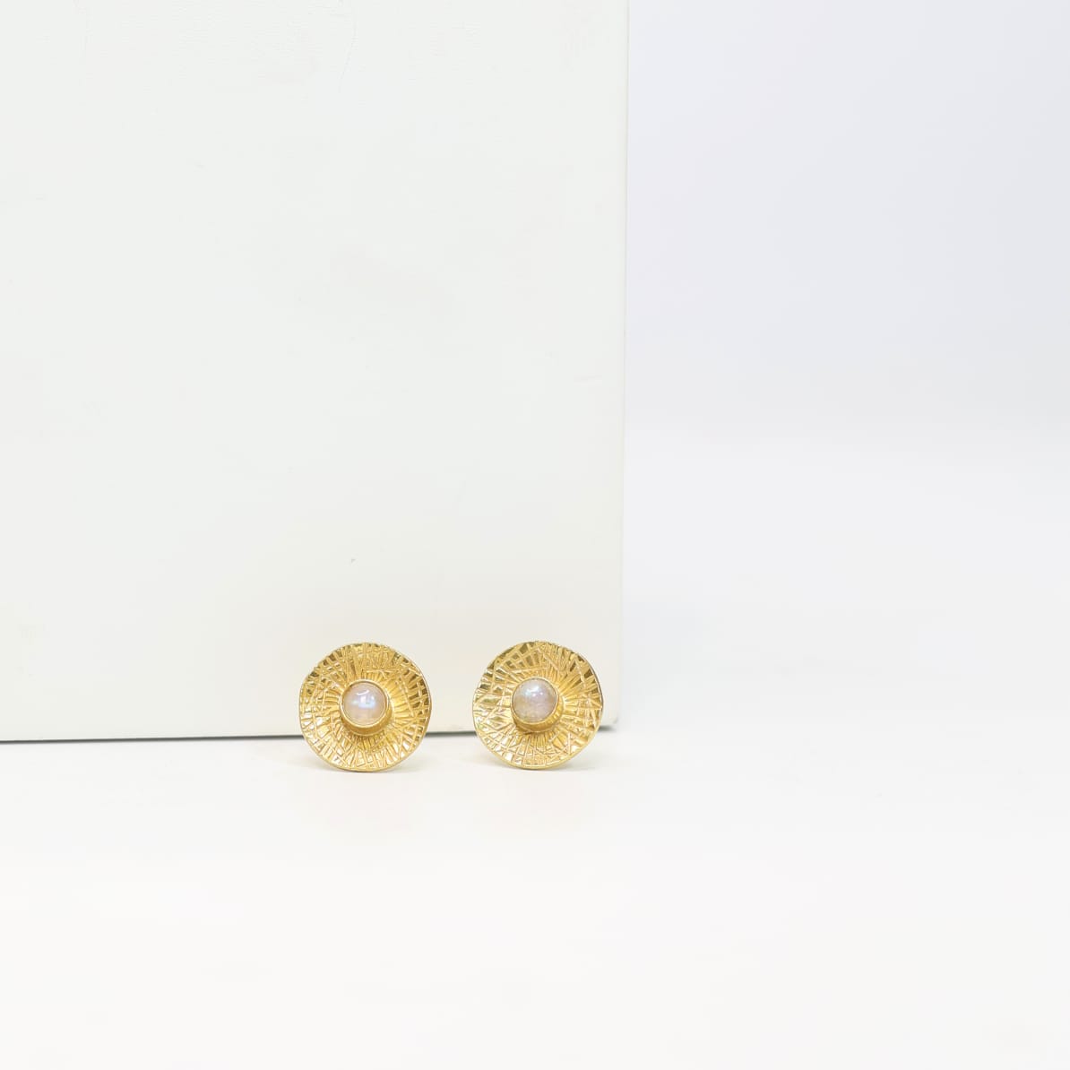Sterling Silver stud earrings with 18 karat micron plating patterned tops with moonstones in Push-Post closure.