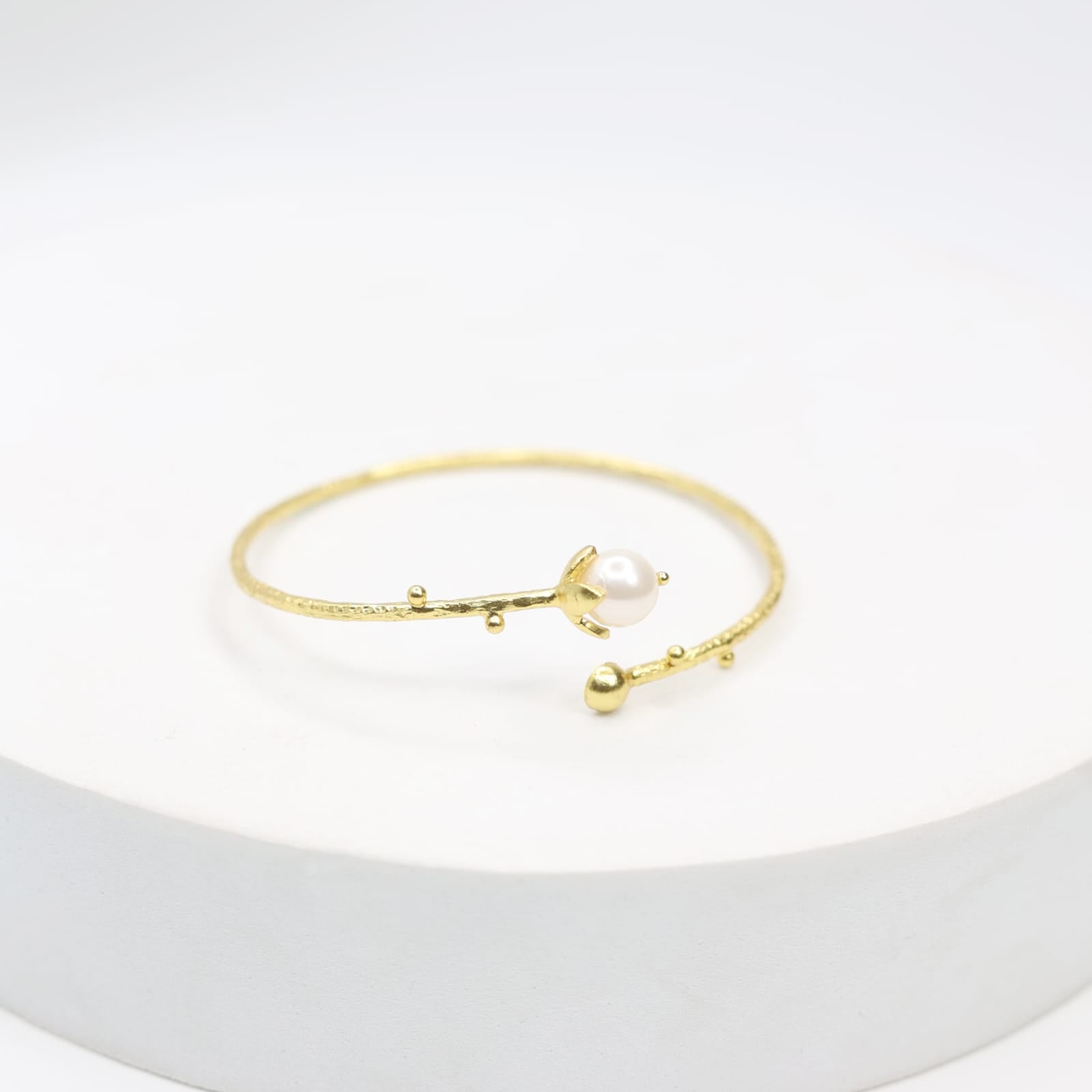 Handcrafted sterling Silver bracelet with 1 micron gold plating in Swarovski pearl with Textured open stacking.
Size- Adjustable