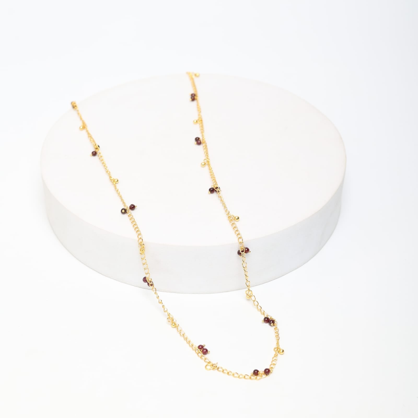 Sterling Silver chain with Garnet and ghungroos in 18 karat Gold plating.