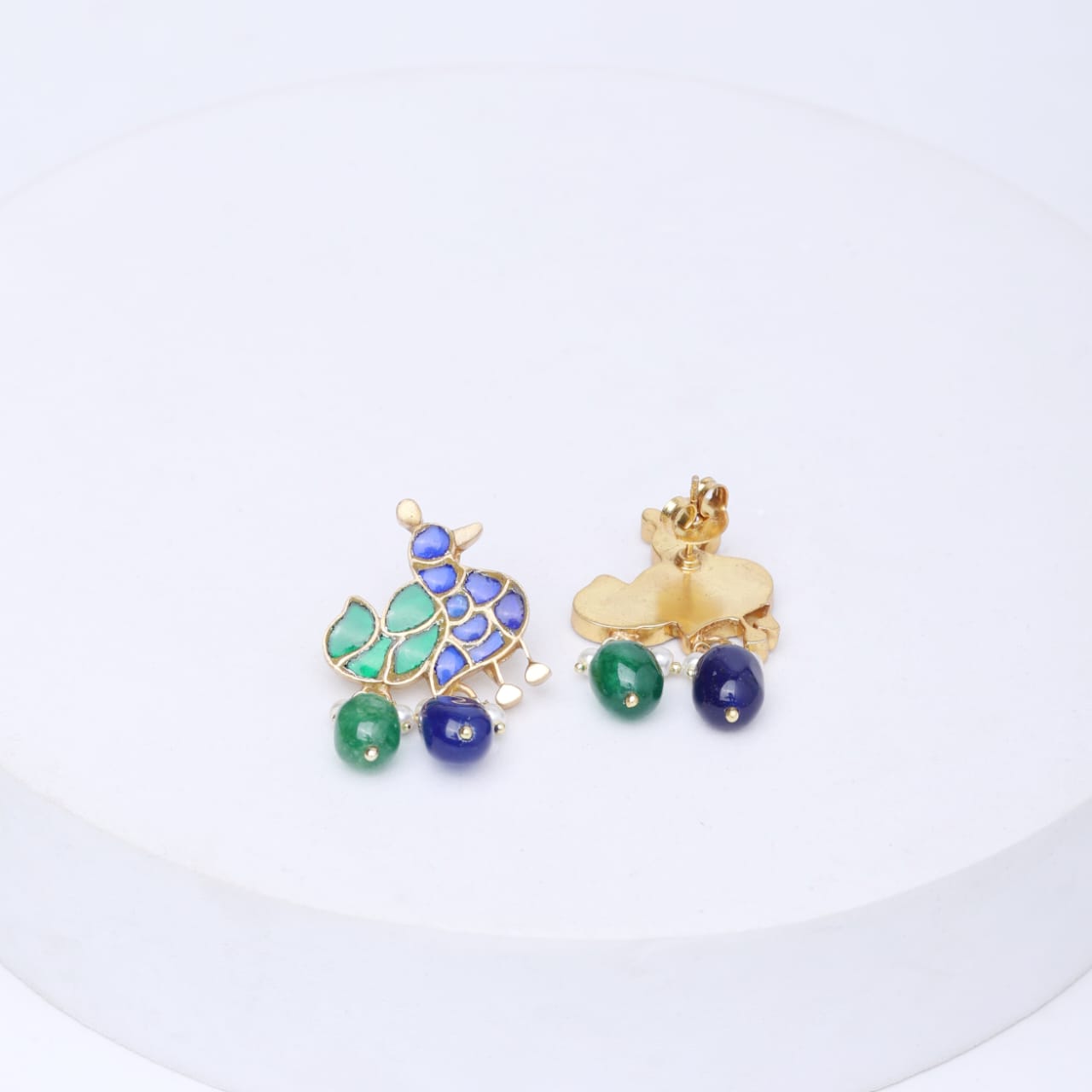 Mayur earrings in Sterling Silver with blue and green Jadau stones in
18 k micron Gold plating,
Green onyx, blue chalcydony drops in
Pin-Post closure.