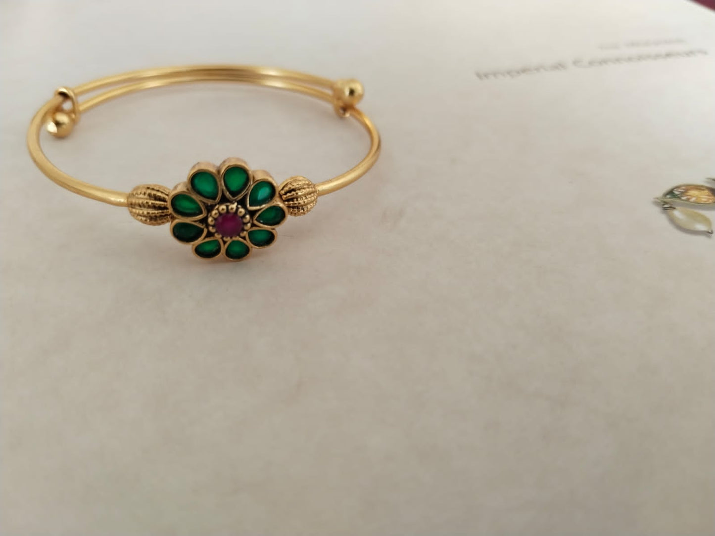 Sterling silver phool, adjustable bracelet with red and green Jadau stones, 24 karat micron gold plating.